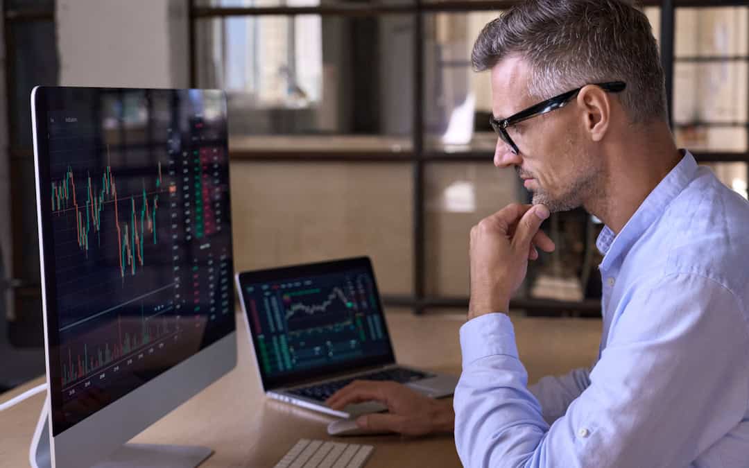 Man thinking about financial graphs with eyes focused on computer screen.