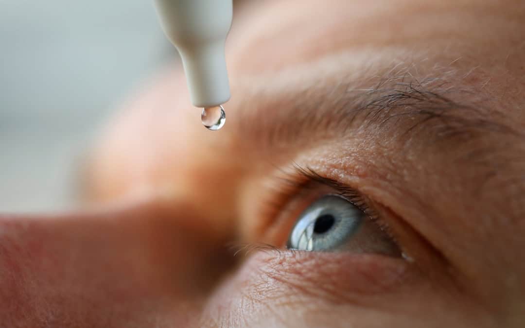 Man applies eye drop medication for glaucoma treatment in Pittsburgh.