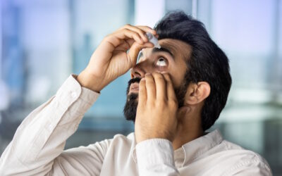 Man in Pittsburgh uses eye drops to relieve dry eye symptoms.