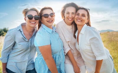Happy group of four women smiling outdoors.
