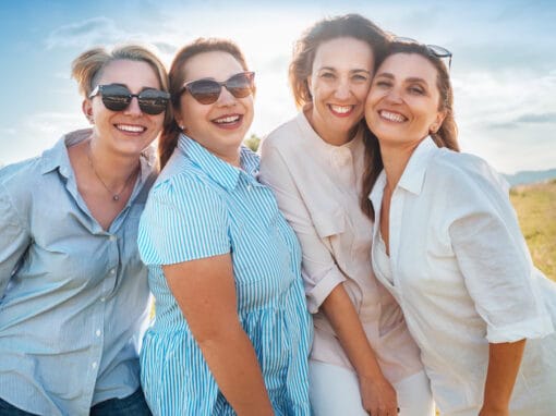 Happy group of four women smiling outdoors.