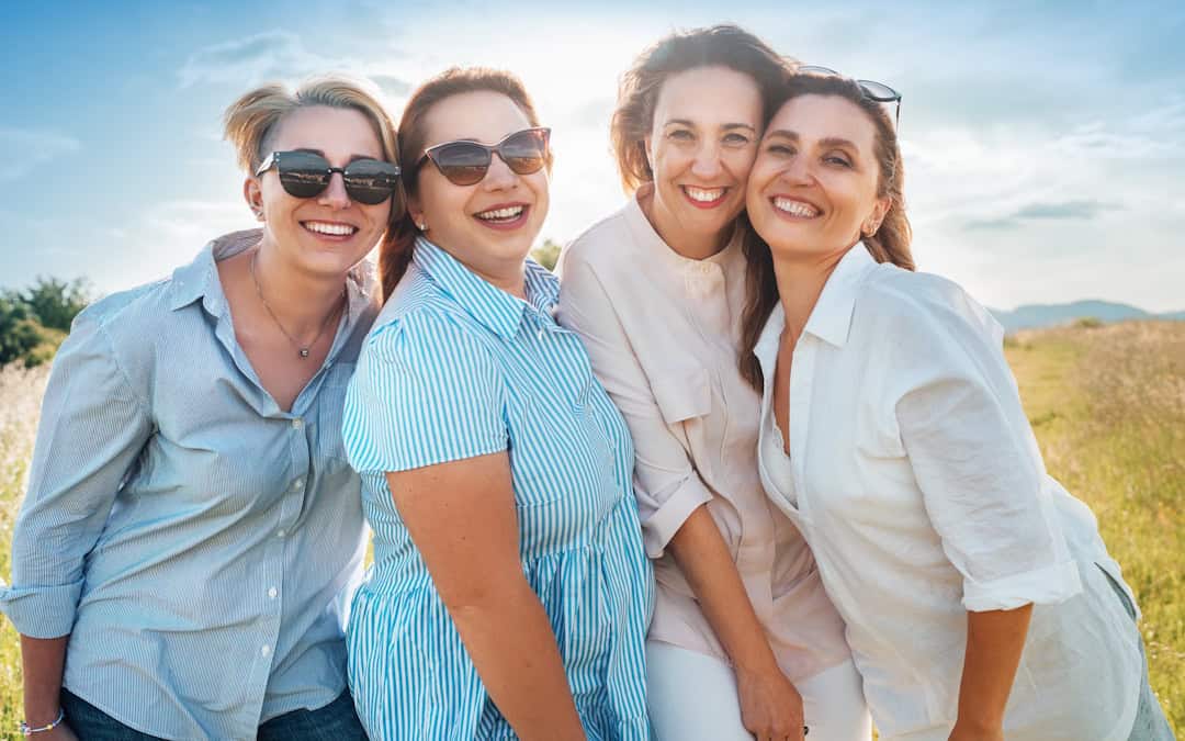 Happy group of four women smiling outdoors.