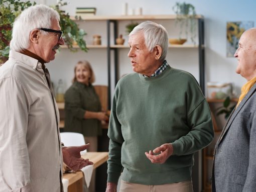 Three senior adult men socializing in Pittsburgh discussing signs of potential hearing loss.