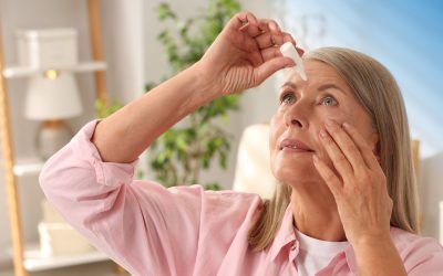 A senior woman in Pittsburgh applies eye drops to relieve dry eye symptoms.