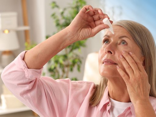 A senior woman in Pittsburgh applies eye drops to relieve dry eye symptoms.