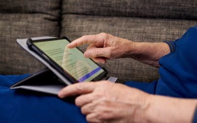 Senior woman in Pittsburgh reading using tablet device as low vision aid for macular degeneration.