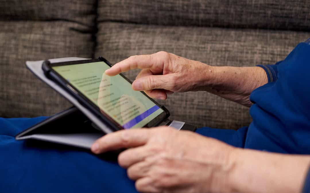 senior-woman-using-tablet-low-vision-device Senior woman in Pittsburgh reading using tablet device as low vision aid for macular degeneration.