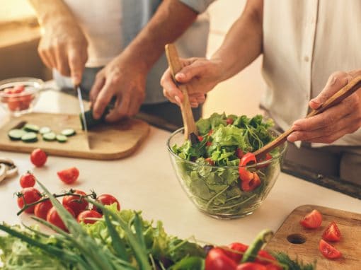Adults in Pittsburgh preparing healthy meal to help prevent hearing loss.