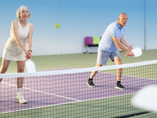 Senior couple with clear vision in Pittsburgh playing pickleball.