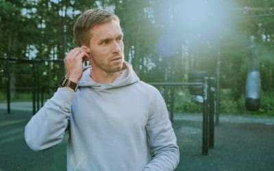 Adult man adjusting earbuds to help protect hearing.